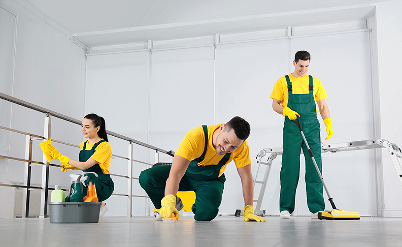 Team of professional janitors cleaning room after renovation