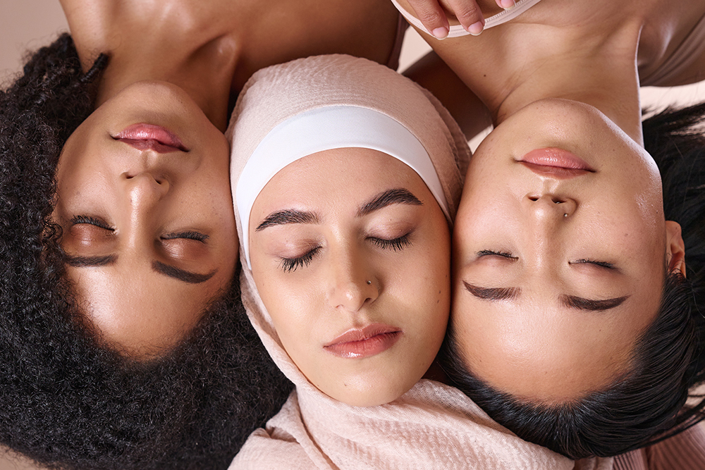 Retrato de tres mujeres con los ojos cerrados de distintas culturas