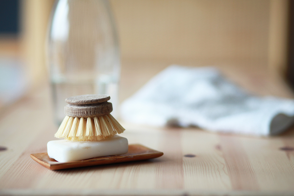 Biodegradable soap and hand brush on a wooden table